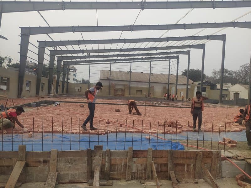 Workers laying floor inside steel frame